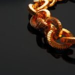 Protecting Your Jewelry: How to Avoid Common Damages and Wear golden chain necklace on black background with ref vtjk95q