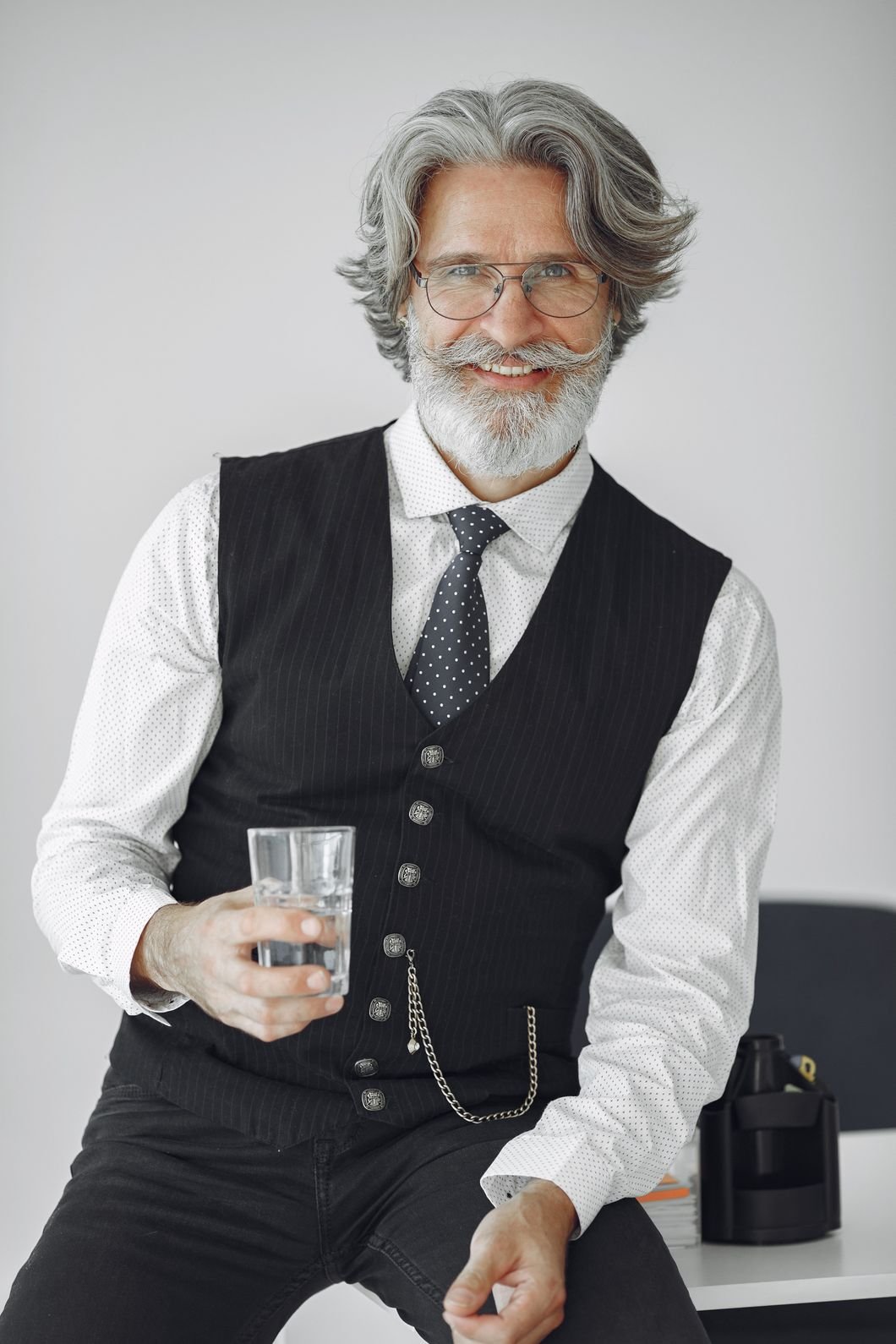 handsome old businessman sitting with glass of wat 3z3z5k7.jpg